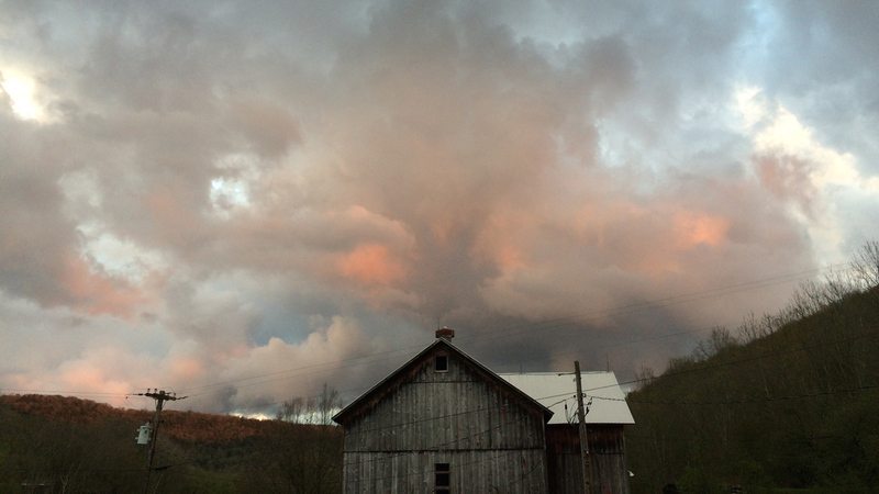 numinous clouds over barn in forest